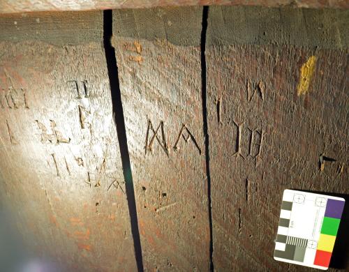 12. M or butterfly symbol and A (likely apotropaic), followed by I H.  Back of rood screen.