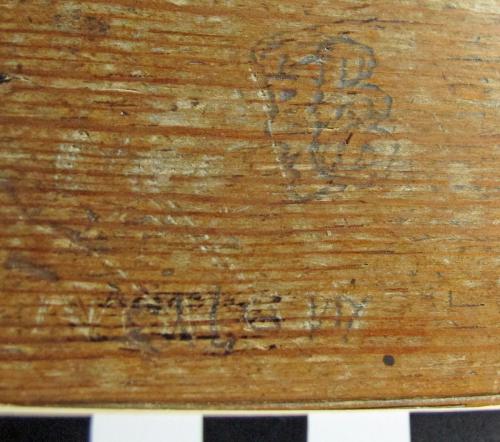 Broadhempston 16.  Choir stall. Modern head with wavy hair, facing left.  Illegible word beneath.